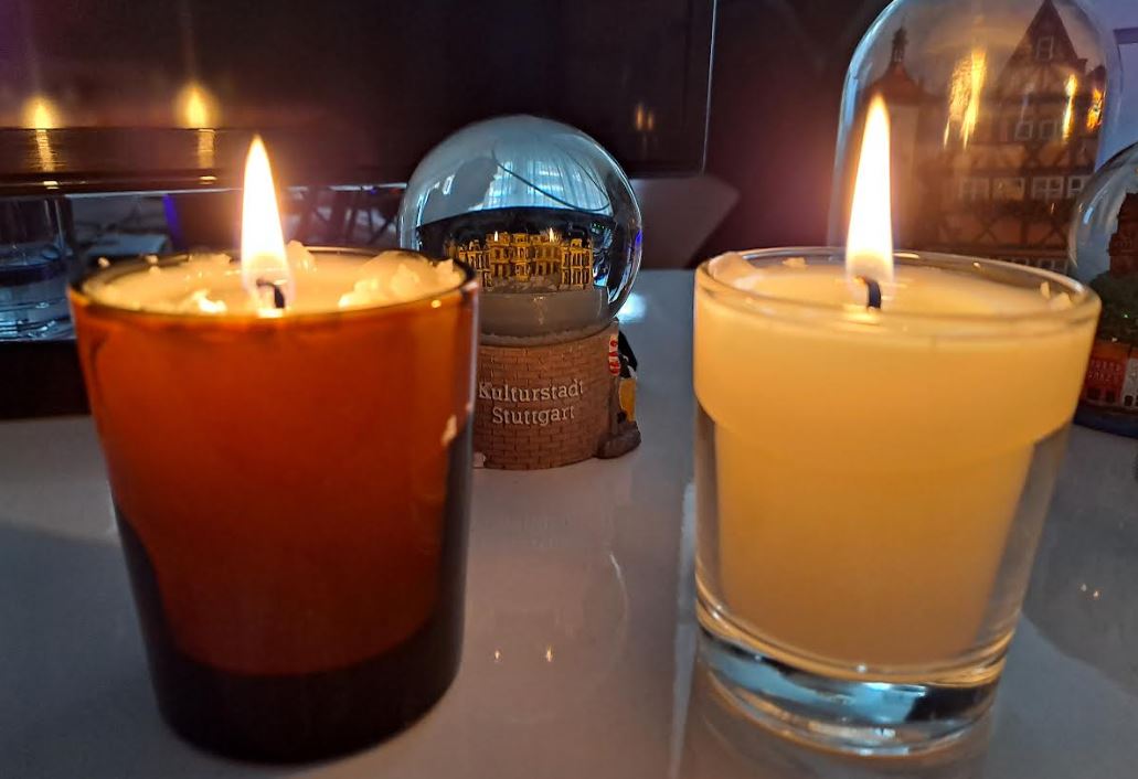 Velas encendidas de cera de abeja artesanas y en vasos de vidrio