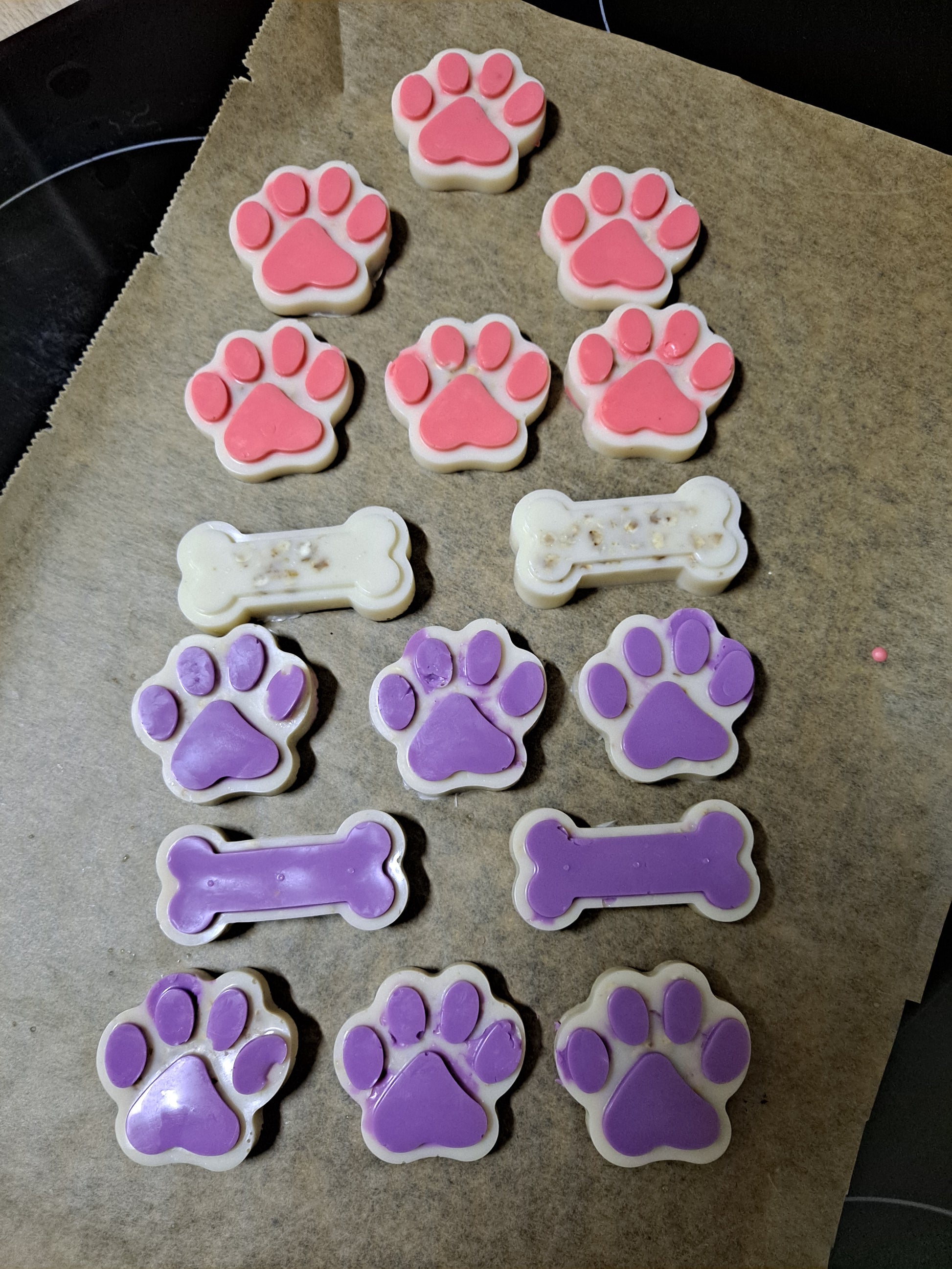 Jabones de avena aptos para mascotas recién sacados del molde, con forma de huella y de hueso