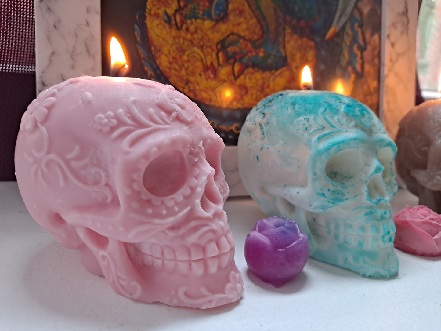 Detalles de velas encendidas de varios colores con forma de calavera